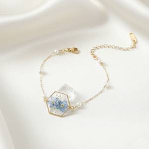 hexagonal resin bracelet with blue dried flowers, gold chain, and pearls
