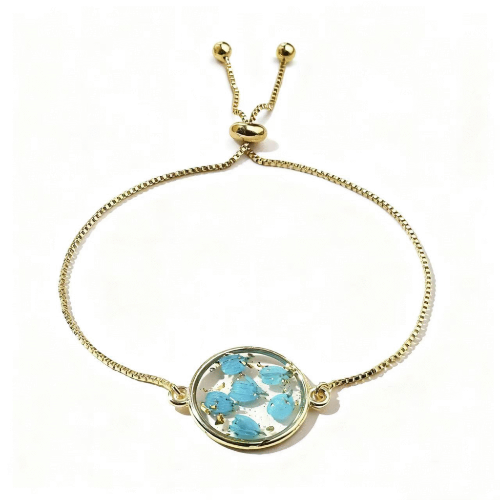 gold adjustable bracelet with blue pressed flower charm