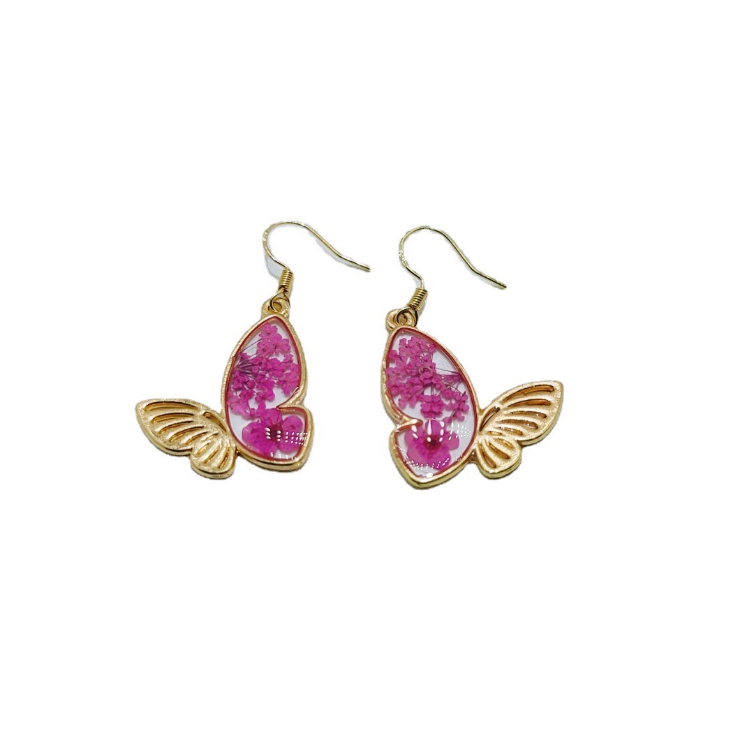 Pink butterfly resin earrings on white background