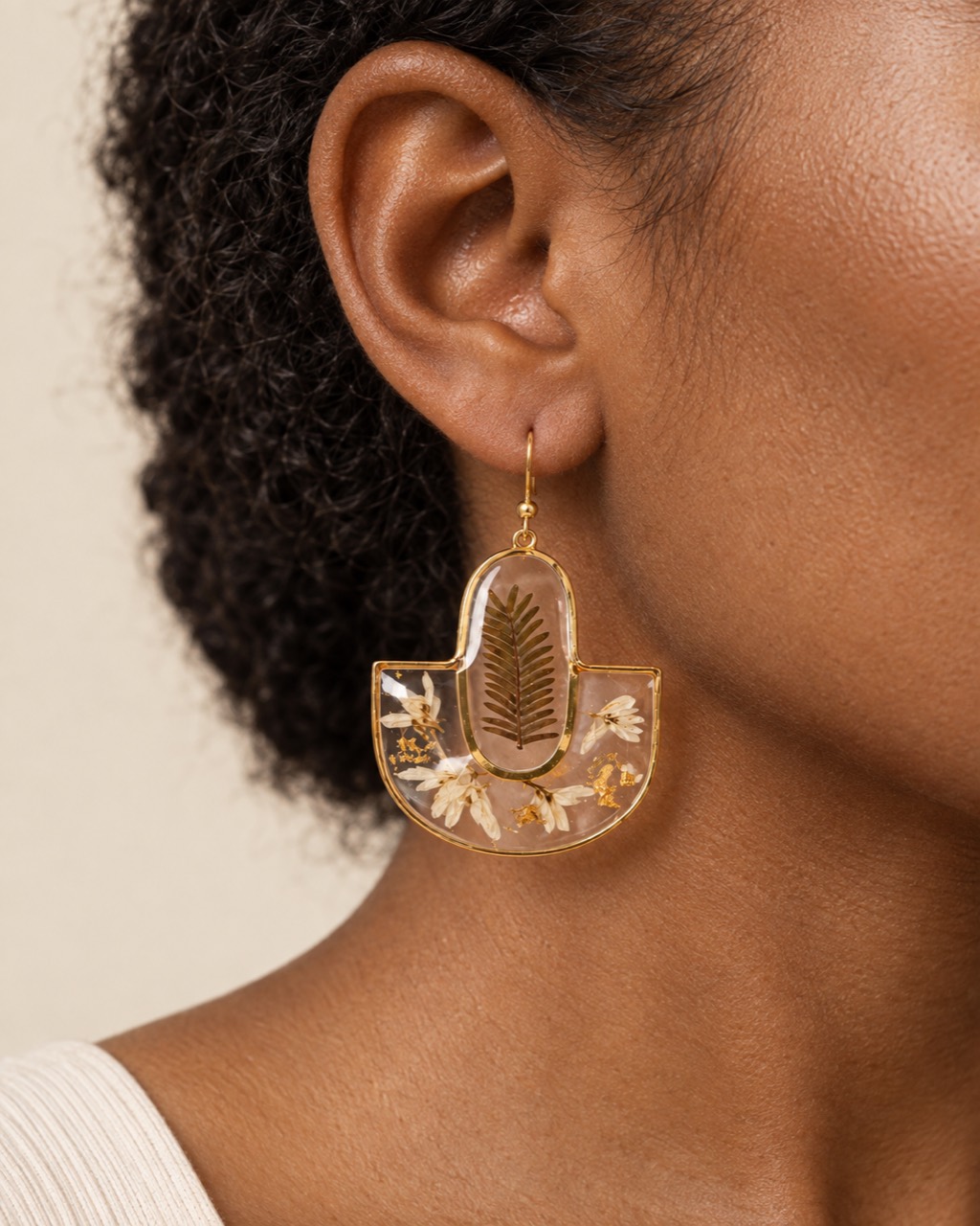 Botanical arch drop earring with fern motif shown on a model